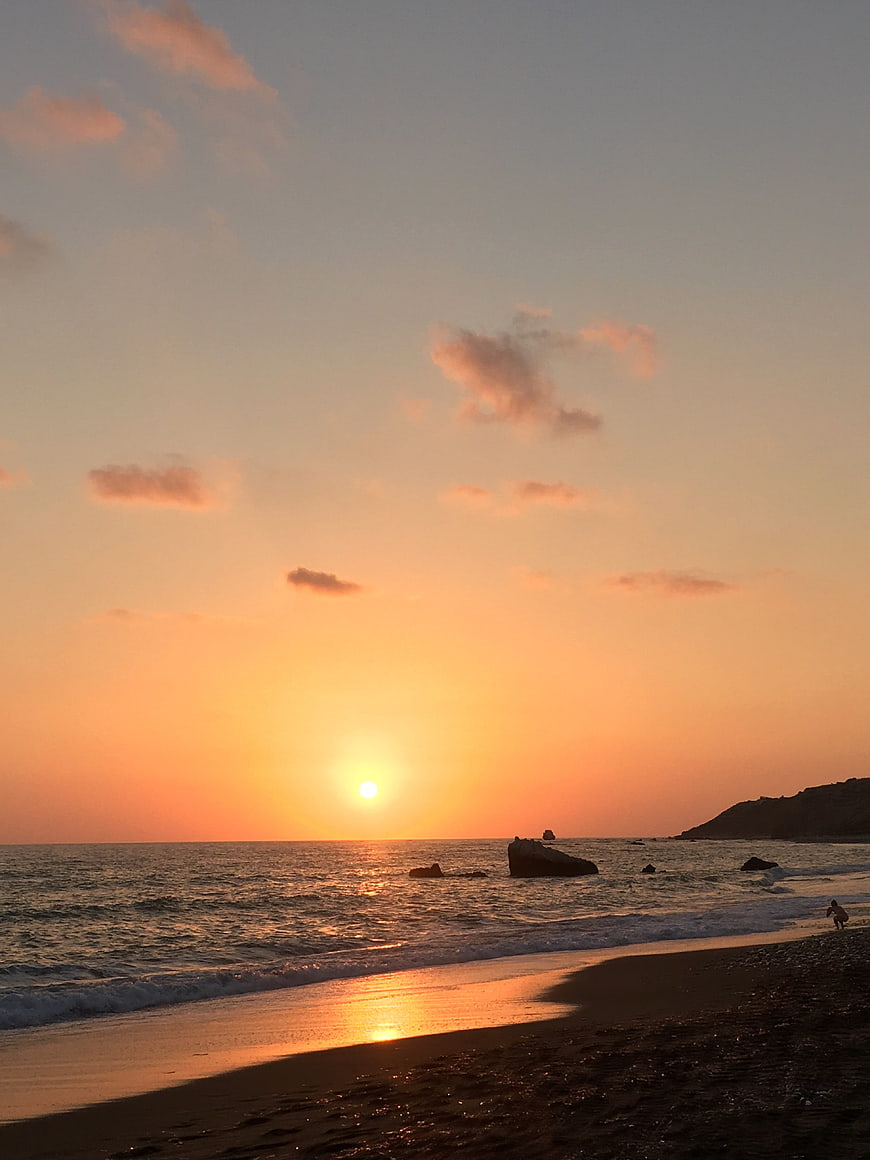 Serene Sunset Over Ocean Beach with Golden Sky
