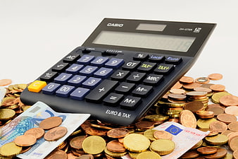 Casio Calculator Resting On Pile Of Euro Coins And Banknotes
