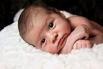 Close-up portrait of a newborn baby on a white blanket