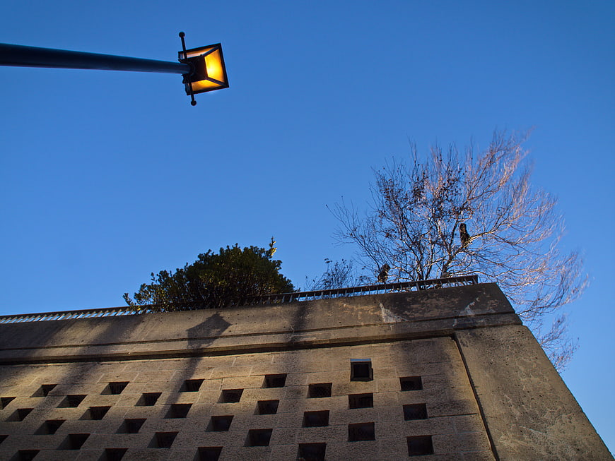 Low angle view of street lamp and concrete building against blue sky