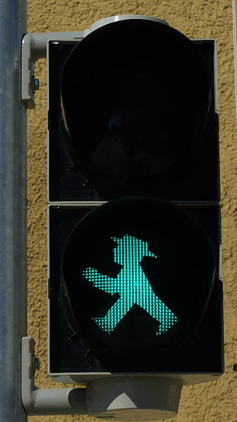 Green pedestrian traffic light with walking man symbol