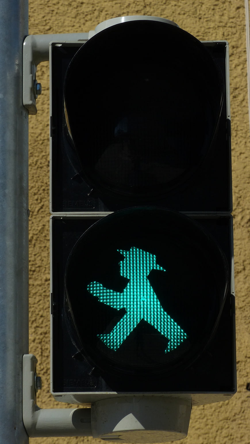 Green pedestrian traffic light with walking man symbol
