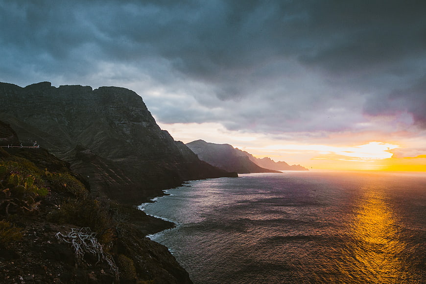 Dramatic Sunset Over Rugged Coastal Mountains and Ocean