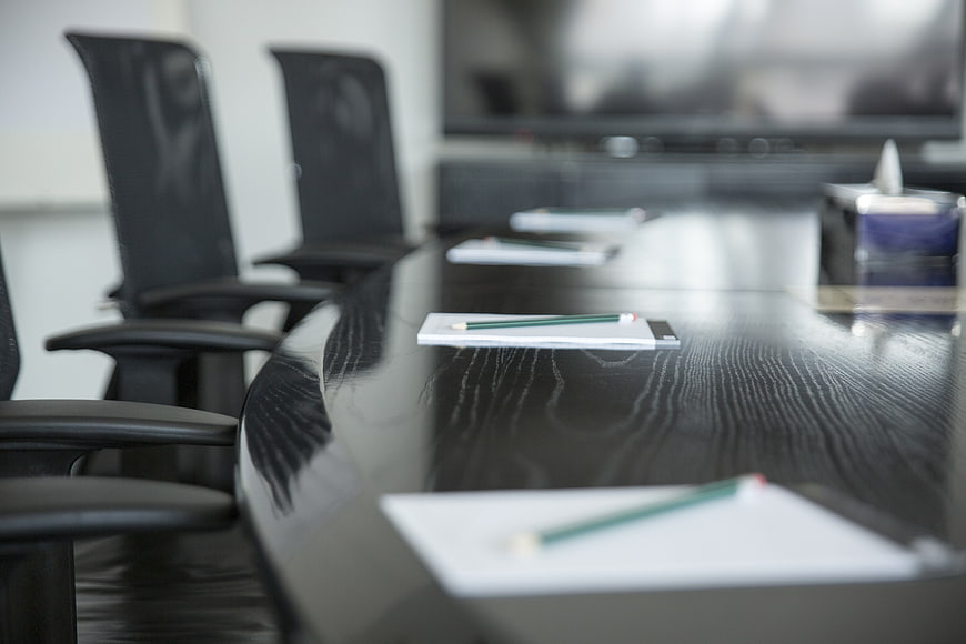 Empty modern conference room with black table and chairs