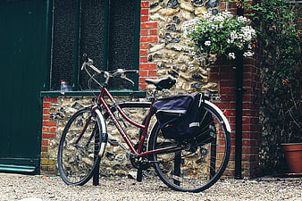 Vintage Maroon Bicycle Parked Against Stone Wall