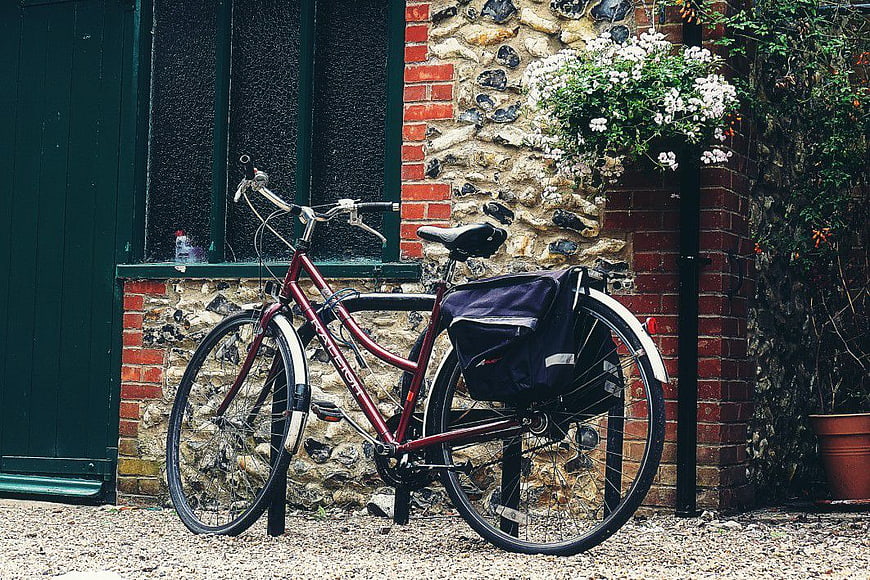 Vintage Maroon Bicycle Parked Against Stone Wall