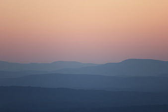 Layered Mountain Silhouettes at Dusk with Pastel Sky