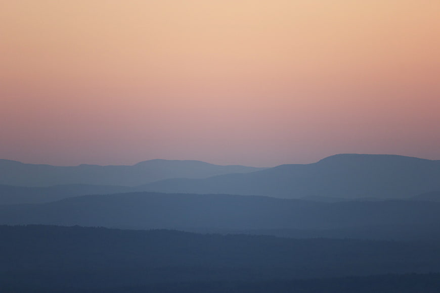 Layered Mountain Silhouettes at Dusk with Pastel Sky
