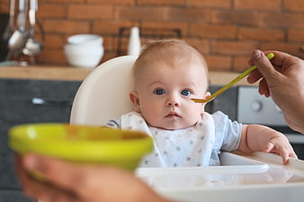 Baby Eating Puree in High Chair