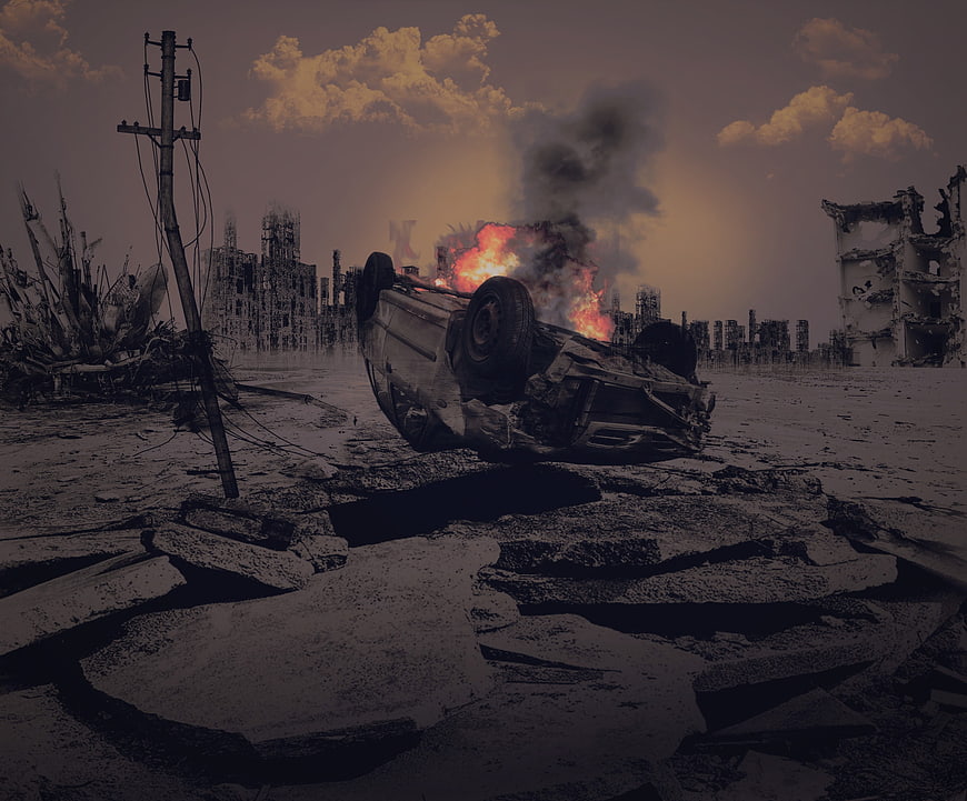 Overturned burning car in post-apocalyptic ruined city landscape