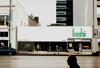 Freshii storefront on a sunny city street with pedestrians