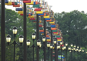 Colorful ski lift chairs and vintage street lamps in a park