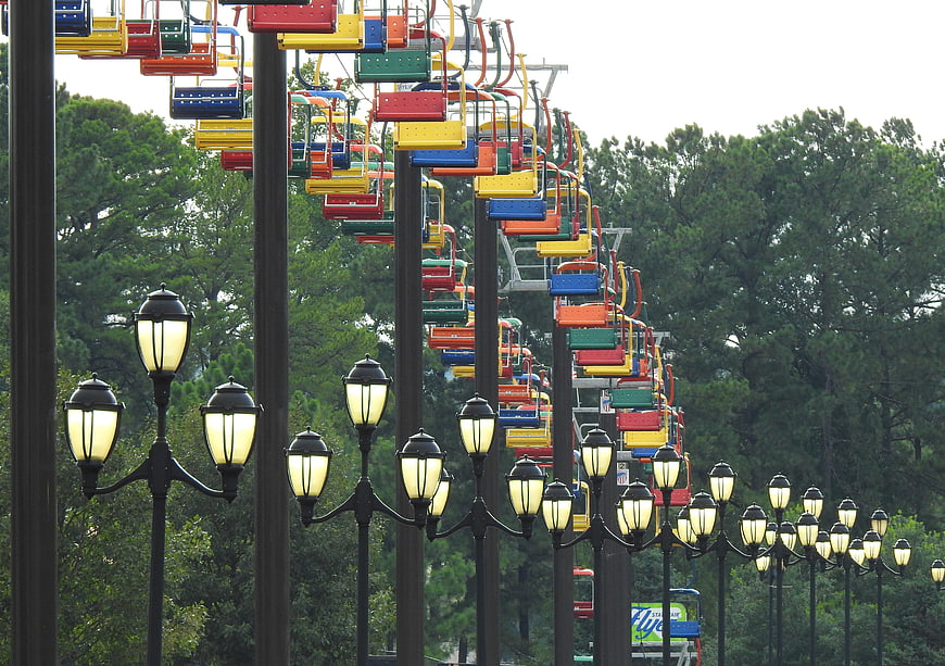 Colorful ski lift chairs and vintage street lamps in a park