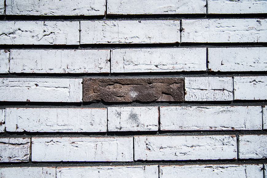 Single brown brick in white painted brick wall texture