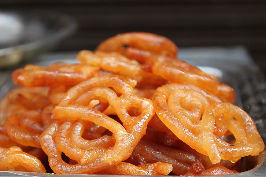 Close-up of golden jalebi Indian dessert on a metal tray