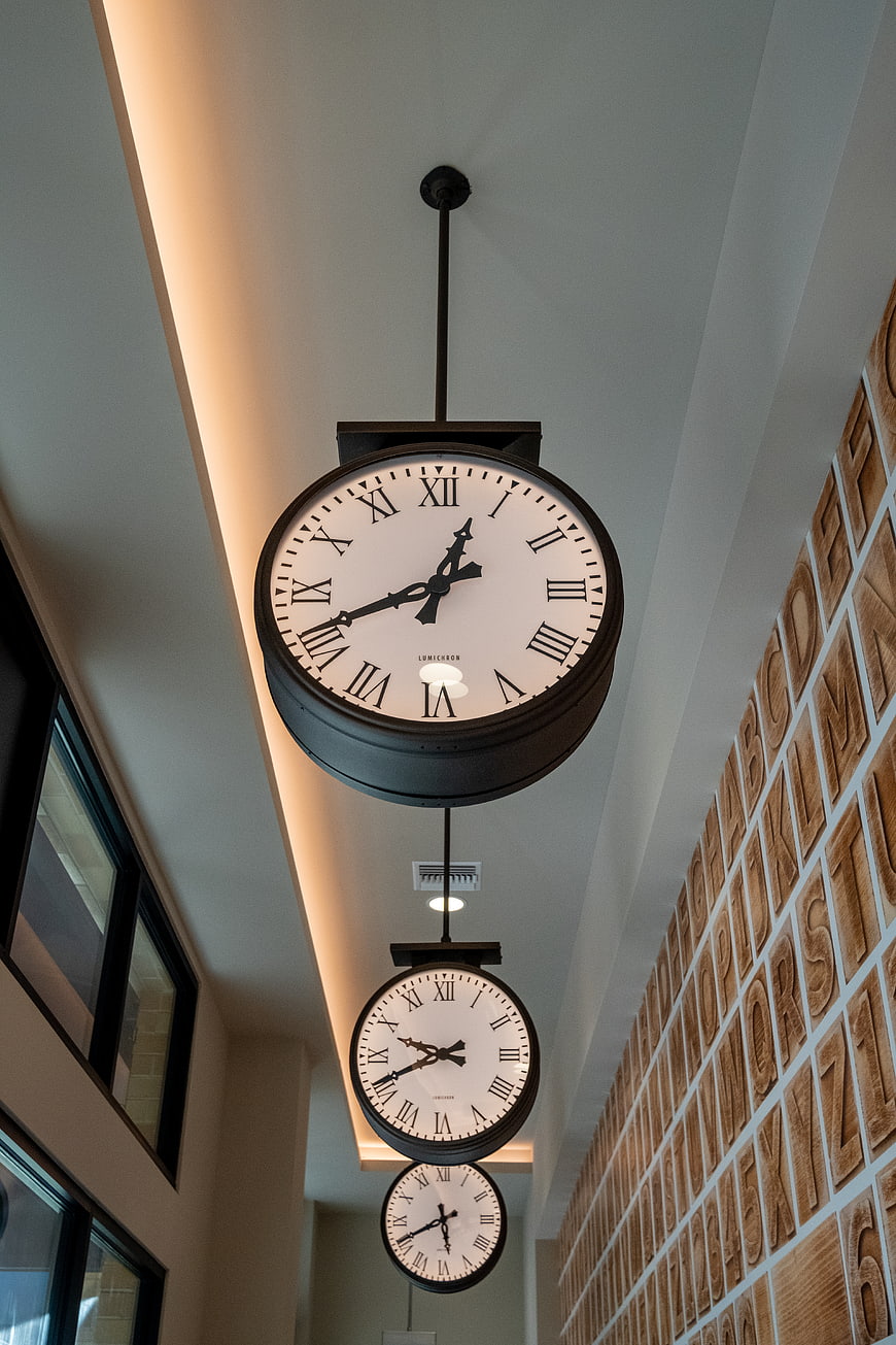Hanging Clocks in Modern Interior with Wooden Alphabet Wall