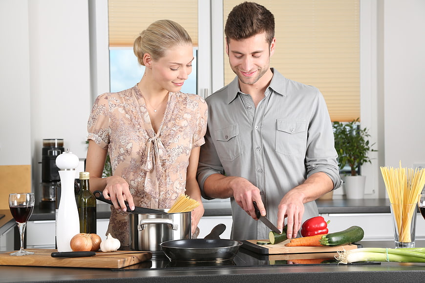 Happy couple cooking dinner together in modern kitchen