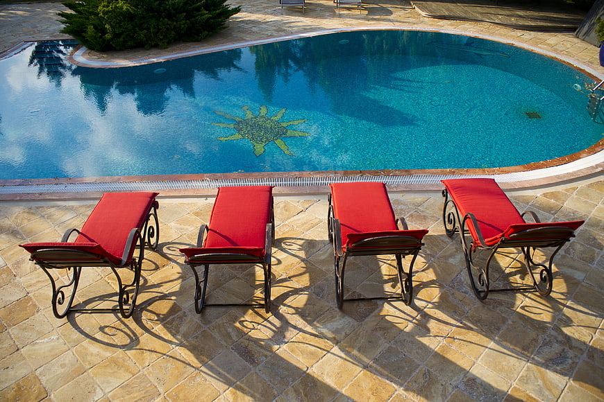 Red Sunbeds by Blue Swimming Pool