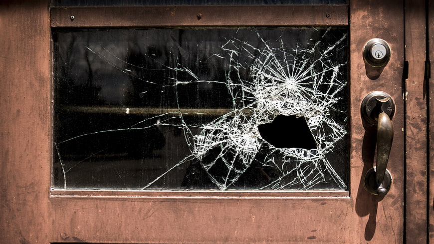Shattered Glass Window on Weathered Wooden Door