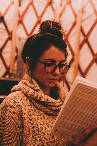 Woman with Glasses Reading Book in Cozy Knit Sweater