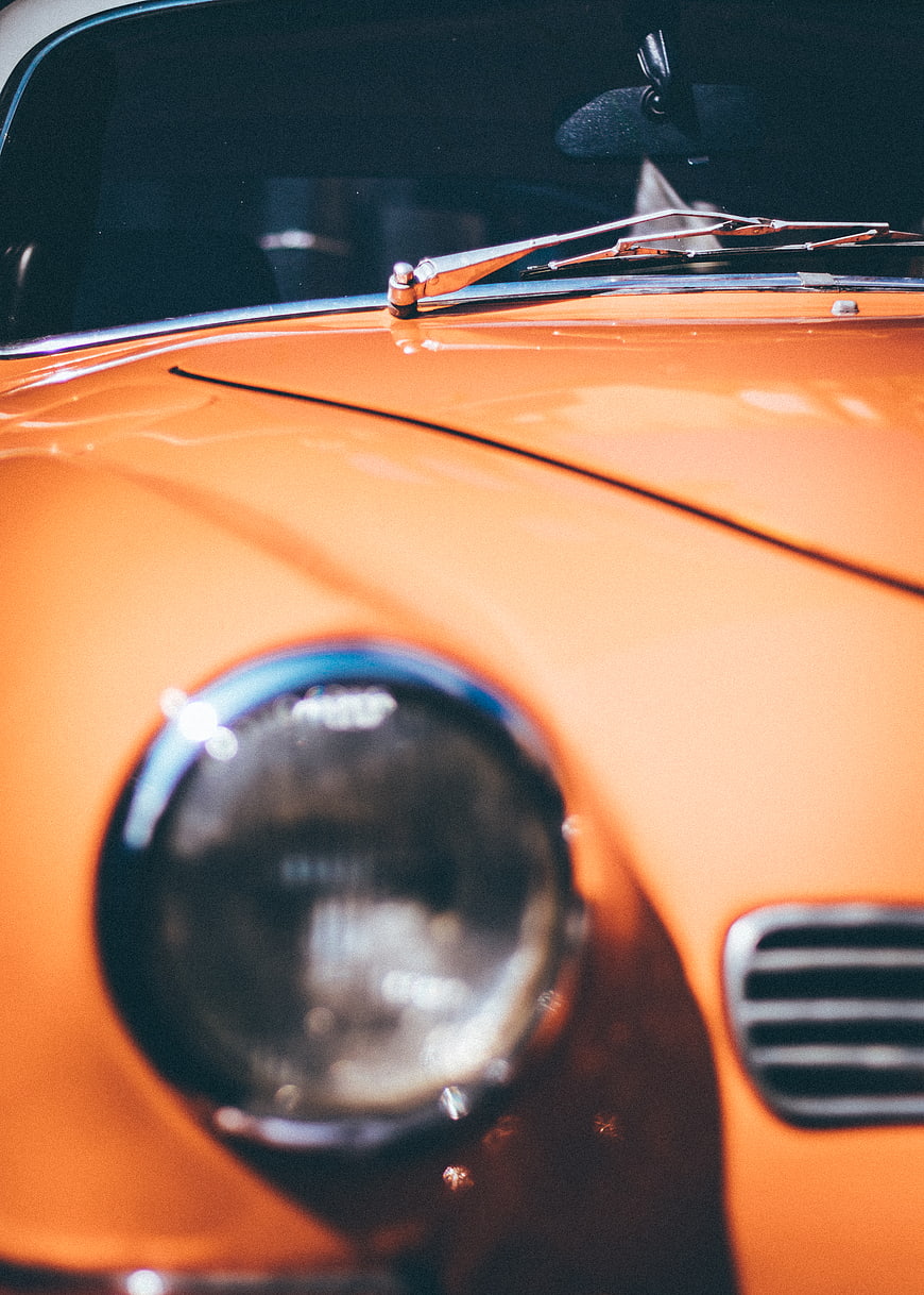 Close-up of vintage orange car hood and headlight