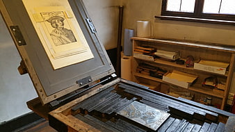 Historic wooden printing press with Albrecht Dürer portrait print in workshop