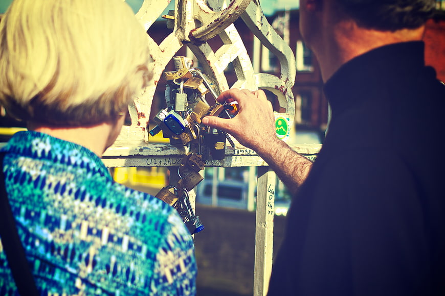 Couple Attaching Love Lock to Bridge Railing