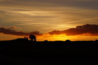 Dramatic sunset silhouette landscape with golden clouds