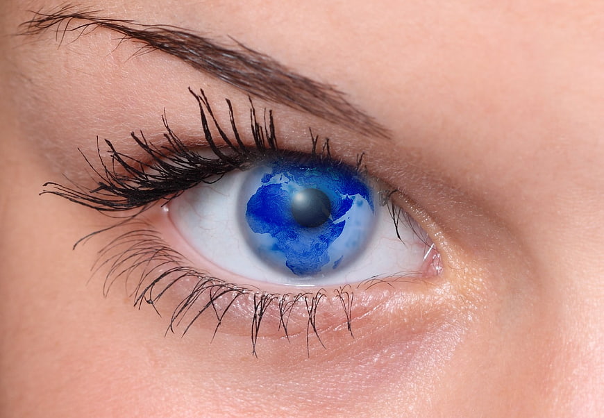 Close-up of eye with blue earth globe reflection in pupil