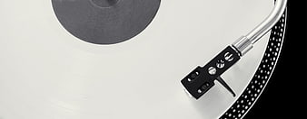 Close-up of turntable needle on white vinyl record