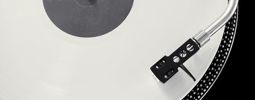 Close-up of turntable needle on white vinyl record