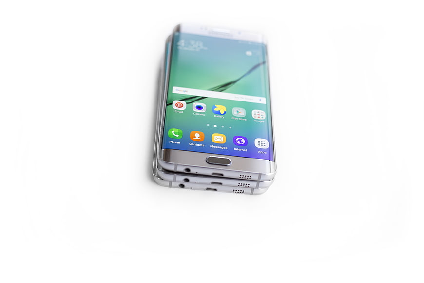 Stack of silver smartphones on white background