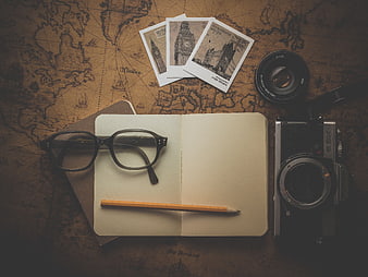 Vintage travel flat lay with camera, notebook, and map