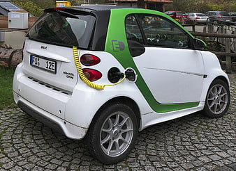 White Smart Electric Drive Car Charging on Cobblestones