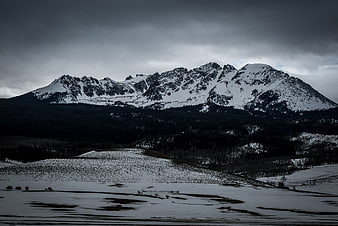 Dramatic Snow-Capped Mountain Range Under Stormy Sky