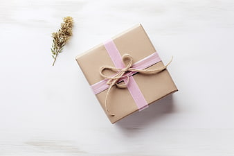 Minimalist Gift Box with Pink Ribbon on White Wood