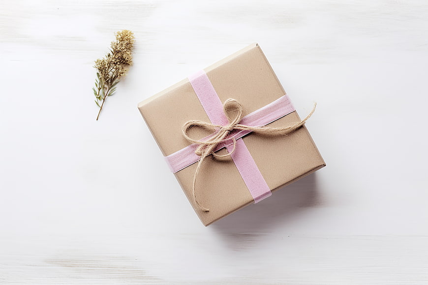 Minimalist Gift Box with Pink Ribbon on White Wood
