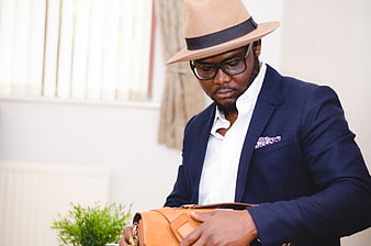 Stylish African American Man in Fedora and Suit Holding Leather Bag