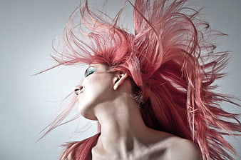 Woman with vibrant pink hair blowing in wind