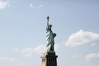 Statue of Liberty against blue sky with clouds