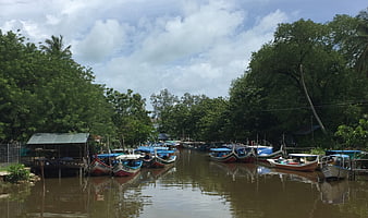 Traditional long-tail boats docked along a tropical river