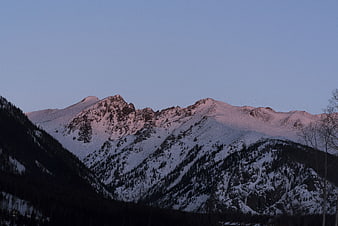 Snowy mountain peaks at dusk with pink alpenglow