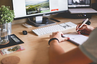 Person working on website layout at desk with computer