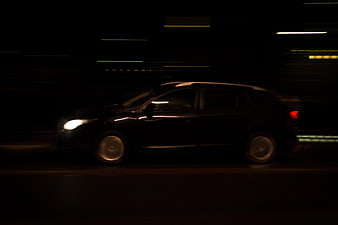 Black SUV driving at night with motion blur