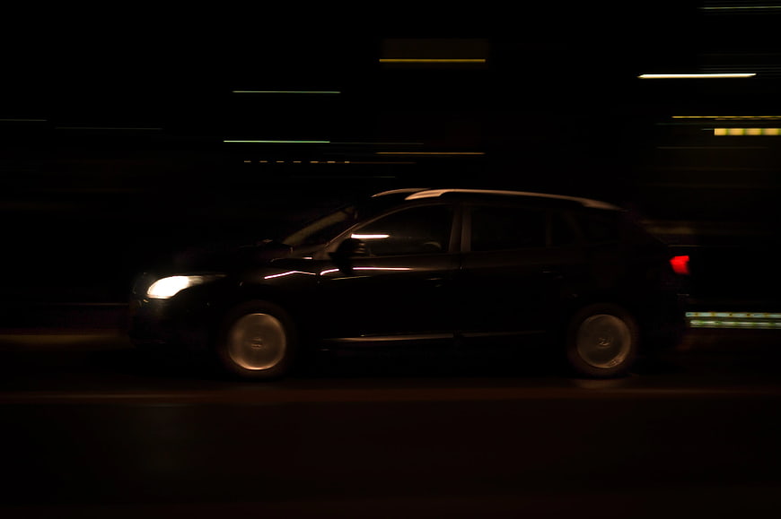 Black SUV driving at night with motion blur