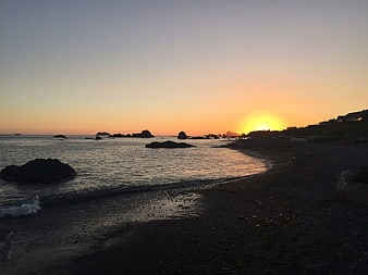 Sunset over rocky Oregon coast beach with ocean waves