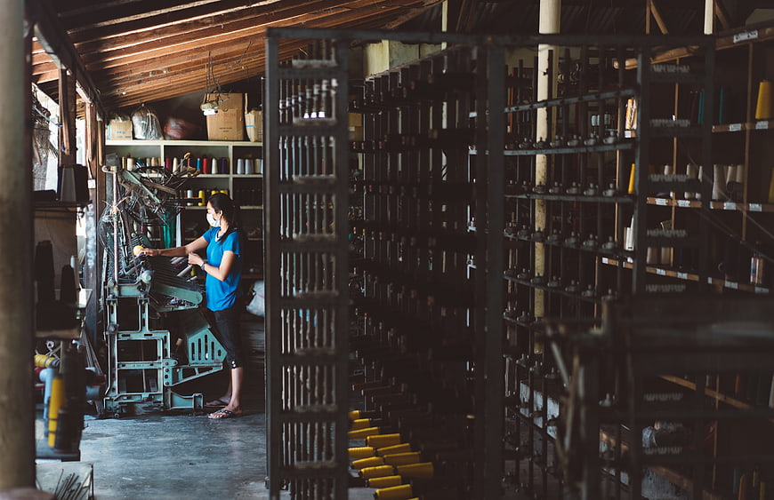 Woman operating textile machinery in a workshop