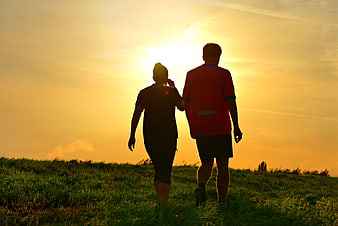 Couple Walking Silhouette Against Golden Sunset Sky
