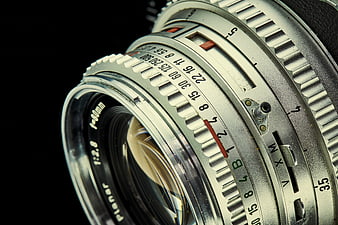 Close-up of vintage silver camera lens with aperture rings