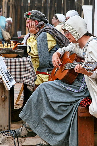 Woman Playing Acoustic Guitar In Medieval Costume At Historical Festival